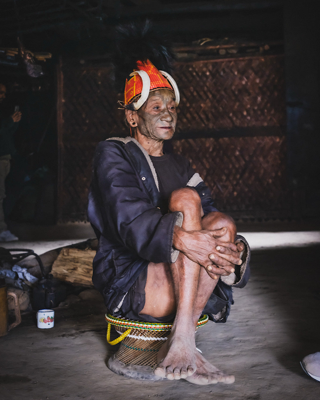 Guerrier Naga au visage couvert de tatouages coiffé d'un chapeau traditionnel à cornes et plumes