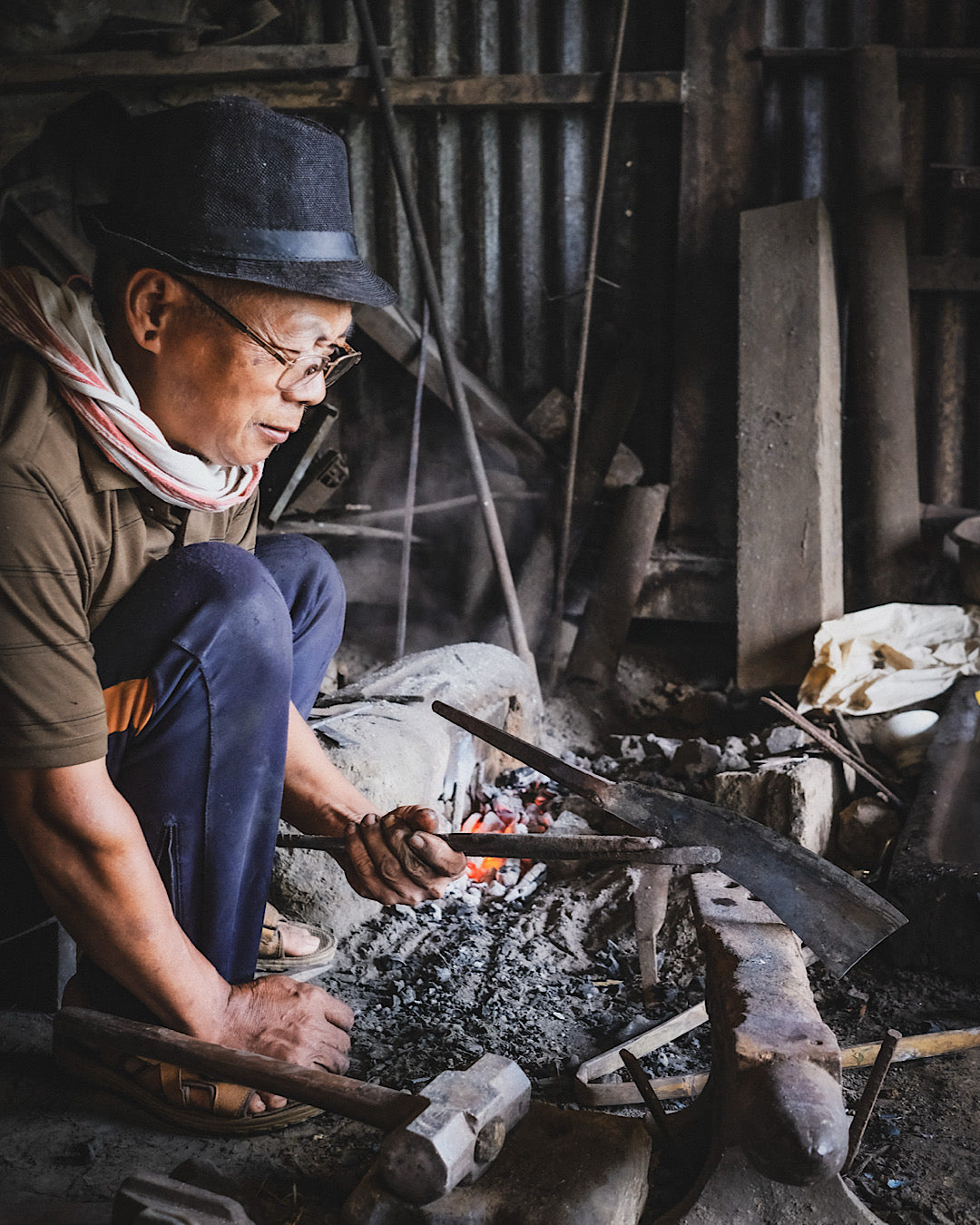 Forgeron du village Naga travaillant la lame d'une machette de manière traditionnelle