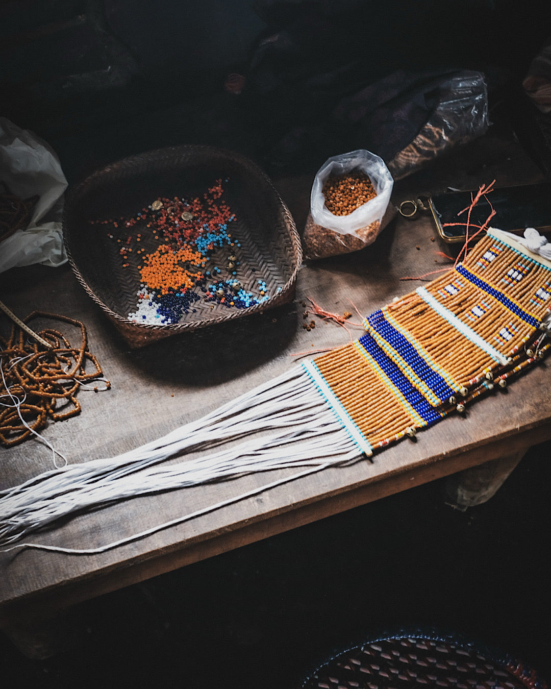 Collier de perles traditionnels en train d'être fabriqués dans une maison du Nagaland